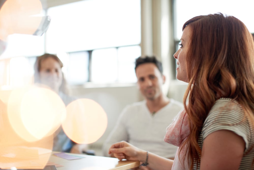 Unposed group of creative business people in an open concept office brainstorming their next project